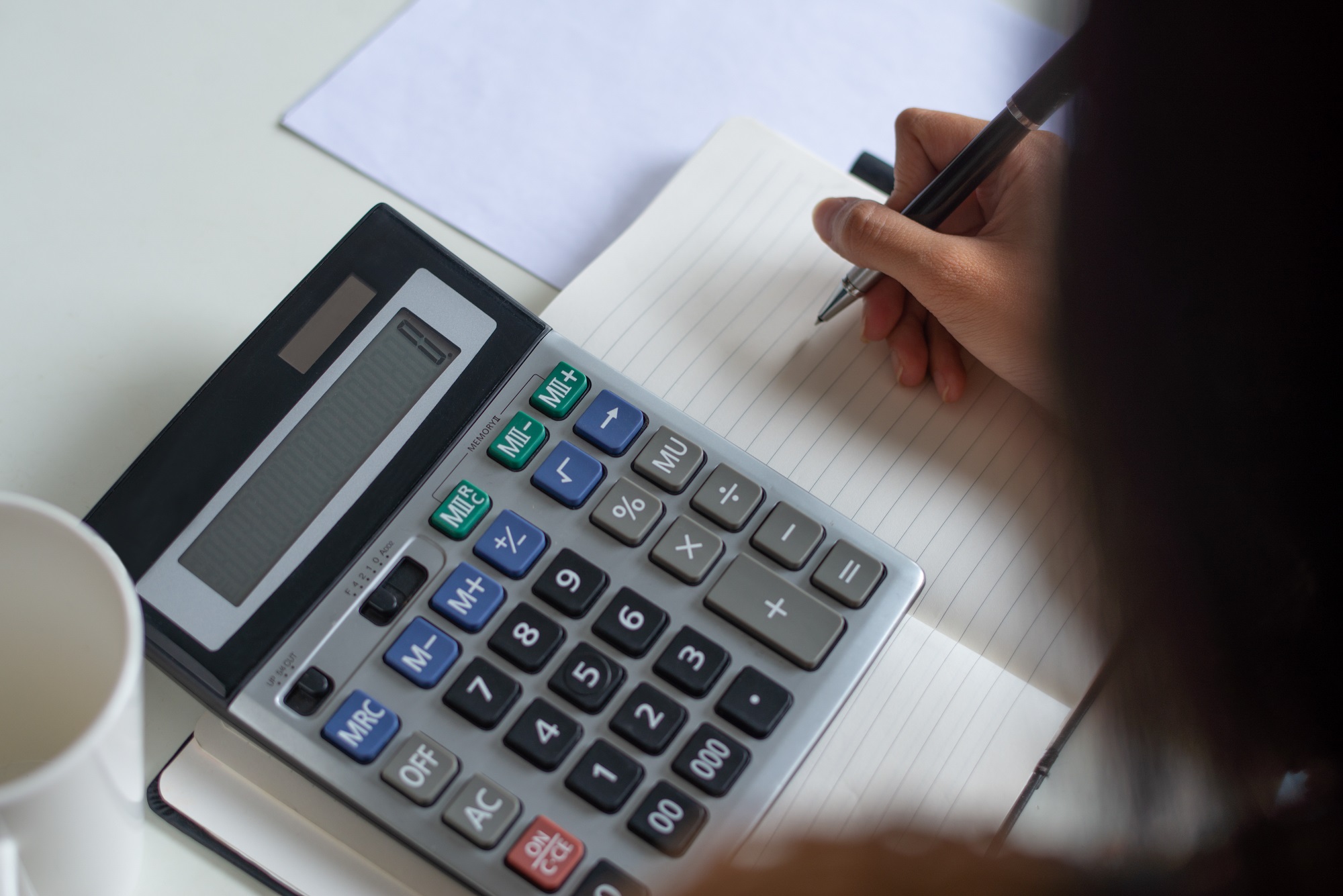 20210831170618-close-up-of-woman-counting-figures-while-preparing-tax-614b715c1b026469545788.jpg